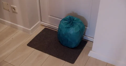 A tight garbage bag at the front door of the house. Slow motion. Stock Footage 145856978