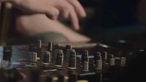 Tight handheld close up of DJ mixing music on professional turntables in a Stock Footage 318860534