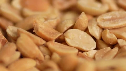 A tight macro close-up of roasted peanuts Stock Footage 328713422