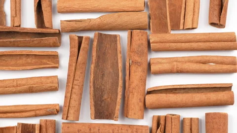 Tight Macro Top View Rotating Cinnamon Sticks On White Background Video stock 331378673