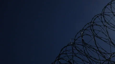 A Tight pan of razor wire atop the US Border fence at Otay Mesa Video stock 48406590