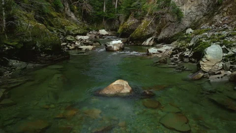 A tight pullback over a the surface of a mountain creek Stock Footage 220936968