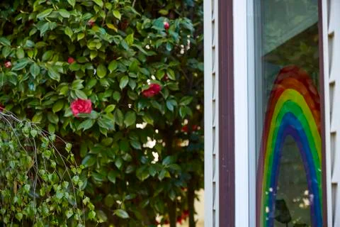 Tight of a rainbow painted on the front window of a home in Portland, OR. Stock Photos