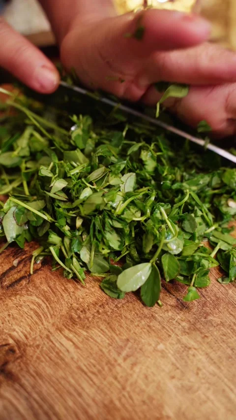 Tight shot of cutting methi or Fenugreek with knife on a chopping board. Stock Footage 283363197