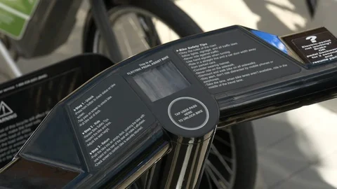 Tight shot of hands using a key fob to check out electric bike. Stock Footage 114245785