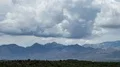 tight shot large thunderhead buildup over mountain range and rain time lapse HD動画