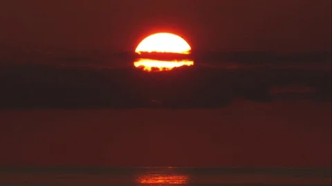 Tight shot of Sun Setting Behind Clouds over the Caribbean Sea Stock Footage 82879131