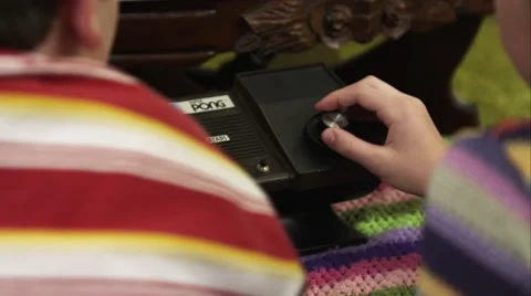 Tight shot of two children playing on an Atari Super Pong console. Video stock 59897665