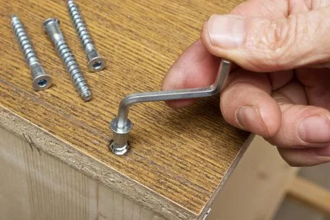 Tightening the screws by hand when assembling furniture Stock Photos