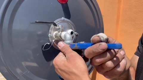 Tightening a Water Heater Pipe Fitting with a Wrench Stock Footage 345209869