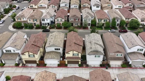 Tightly packed rows of stucco homes with matching terracotta tile rooftops Stock Footage 337453590