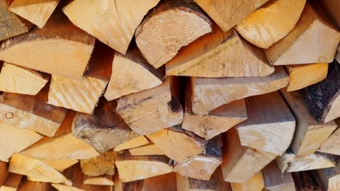 Tightly packed split firewood stacked in bright daylight, showing pale cut Stock Footage 336088673
