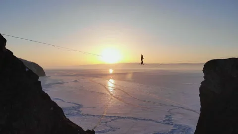 The tightrope Walker is on a rope stretched between the rocks at high altitude. Stock Footage 108131036