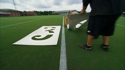 Tiimelapse of workers spraying 30 yard line numbers on football field Stock Footage 105424397