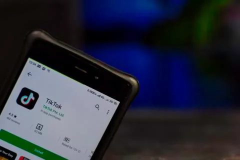 TikTok dev app with magnifying on Smartphone screen. Stock Photos