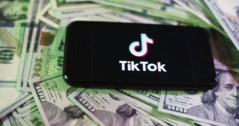 Tiktok Logo on iphone surrounded by $100 Bills. Tiktok Profits Layout Stock Footage 169006513