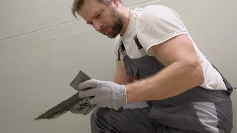 Tile adhesive spreading. Tiling mortar application. Worker smoothing adhesive Stock Footage 333480041
