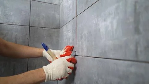 Tile grout. Construction work with ceramic tiles. Grouting, joining wall ti.. Stock Photos