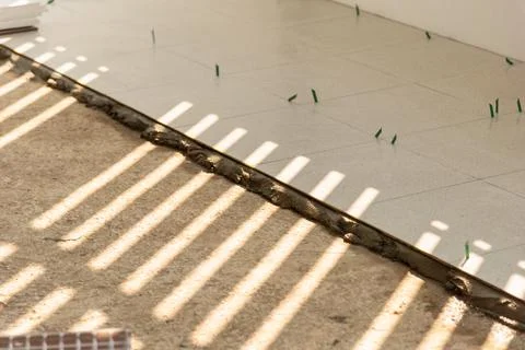 Tile installation process indoor space construction neutral light close-up .. Stock Photos