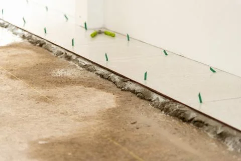 Tile installation process in residential space flooring project close-up vi.. Stock Photos