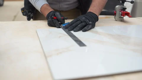 Tile labor measuring and marking large ceramic tile before cutting. Professional Stock Footage 335949695
