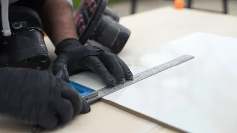 Tile labor measuring and marking ceramic tile before cutting process Stock Footage 335949758
