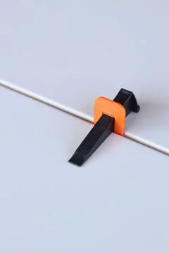 Tile laying process using plastic clamps. Close-up of tile leveling system Stock Photos