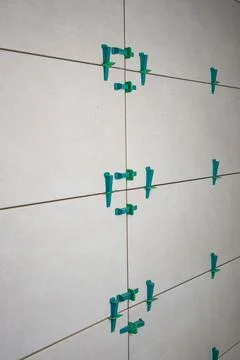 Tile leveling system with plastic clips and wedges, shot while the tile mor.. Stock Photos