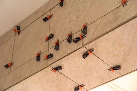 Tile leveling system with plastic clips and wedges, shot while the tile mor.. Fotos Stock