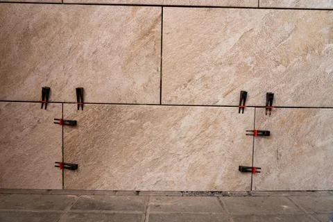 Tile leveling system with plastic clips and wedges, shot while the tile mor.. Stock Photos