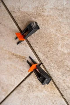 Tile leveling system with plastic clips and wedges, shot while the tile mor.. Stock Photos