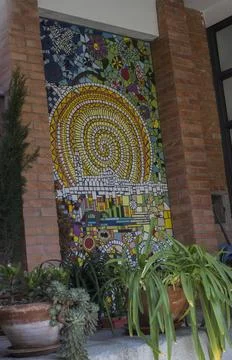 A tile pattern on the wall of a house and some green flowerpots Stock Photos
