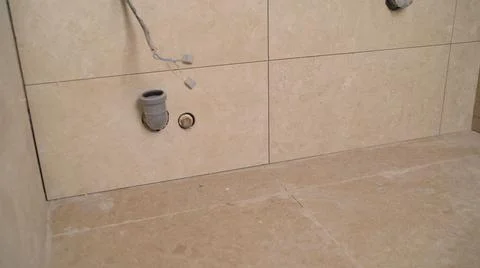 Tile series:Tile border being installed on shower wall in home. Ceramic Floor Stock Photos