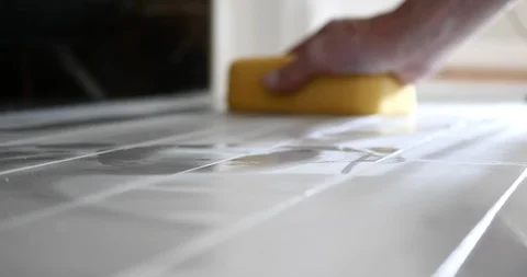 Tile setter's hands sponging off grout on carrara marble subway tile. Stock Footage 129066506