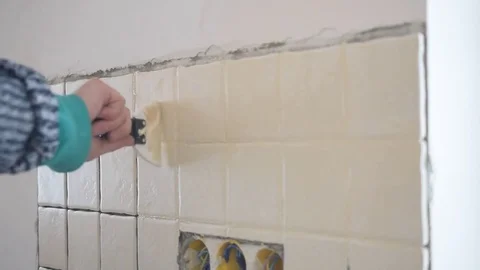 Tile worker filling crevices between tiles with grout Stock Footage 75259596