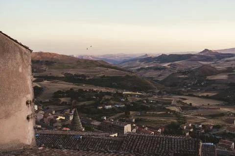 Tiled dome and rooftops overlooking Italian countryside at sunset Stock Photos