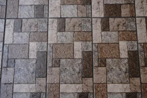 Tiled floor with a pattern of rectangular and square stones in earth tones 写真素材