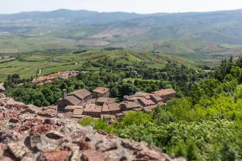 Tiled roofs of the tiny medieval town of Radicofani surrounded by cultivated Stock Photos