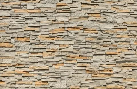 Tiled stone wall made of rectangular blocks, sun shining from top. Stock Photos