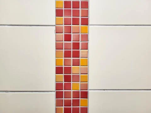 On the tiled wall, there is a pattern of small red tiles Stock Photos