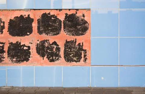 Tiled wall with which part of the tile collapsed. repair work concept Stock Photos