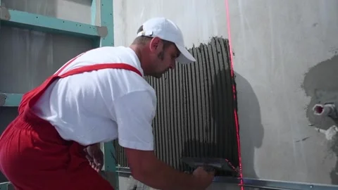 Tiler adding cement mortar on wall before installing ceramic tile in bathroom Stock Footage 91078446