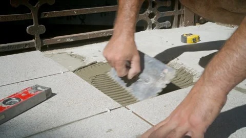 Tiler apply tile adhesive to the concrete surface Stock Footage 245580971