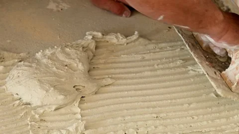 Tiler applying tile adhesive on a floor Stock Footage 346449654