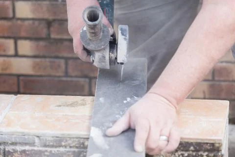 Tiler cutting a tile with a grinder Stock Photos