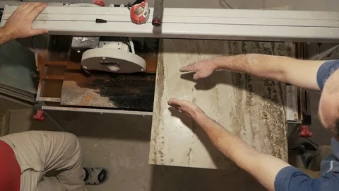 Tiler with a hand-held tile cutter cuts the tile on the floor Stock Footage 103113364