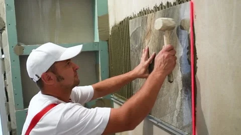 Tiler installing ceramic tile panel in bathroom Stock Footage 91078478