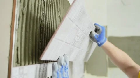 Tiler installing ceramic tile panel in kitchen 動画素材 91171283