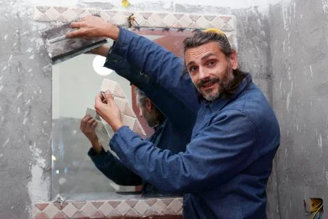 Tiler installing ceramic tiles Stock Photos