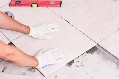 Tiler installing ceramic tiles Stock Photos